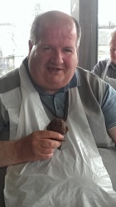 man holding small clay sculpture