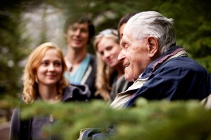 An elderly man telling stories to a group of young people