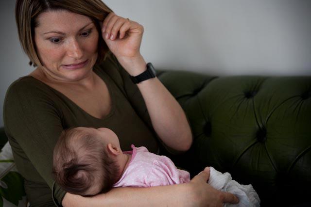 woman holding baby looking shocked