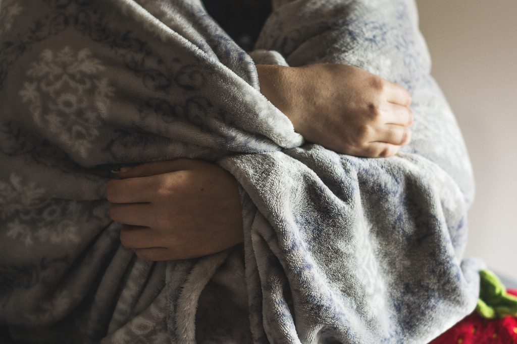 person wearing a blanket to stay warm, face not visible